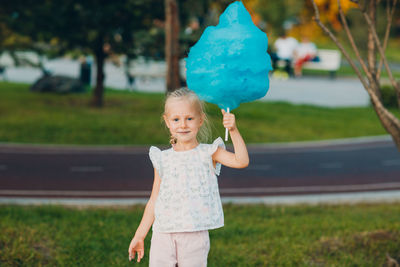 Cute girl holding cotton candy in park
