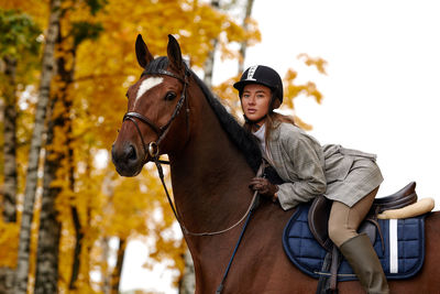 Side view of woman riding horse