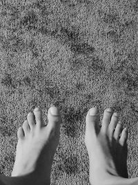 Low section of woman standing on sand