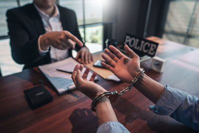 Midsection of couple holding hands on table