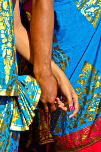 Midsection of woman holding multi colored umbrella