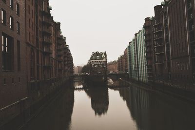 Canal amidst buildings against sky in city