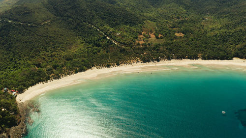 Aerial drone of beautiful tropical beach in cove with blue lagoon and turquoise water. nagtabon