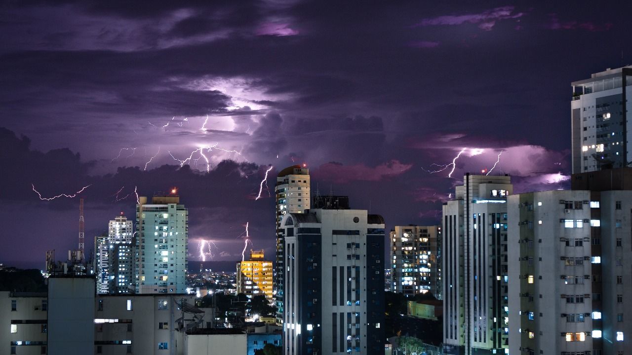 AERIAL VIEW OF ILLUMINATED CITY AGAINST SKY AT NIGHT