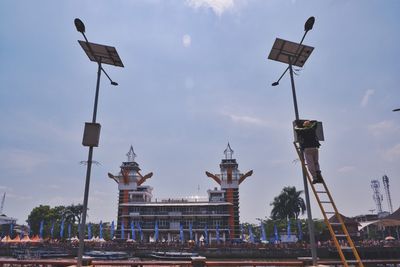 Street light by building against sky