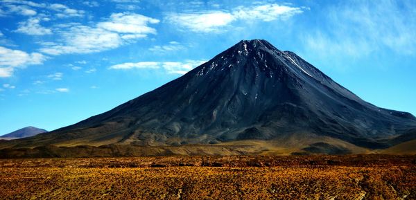 Panoramic shot of countryside landscape against blue sky