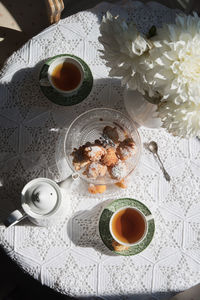 English style tea break, still life with flowers and donuts in the morning sun