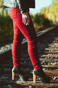 Low section of woman standing on railroad tie