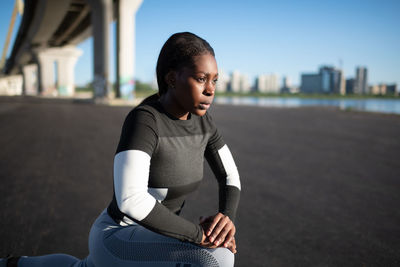 Determined black athlete lunging on street