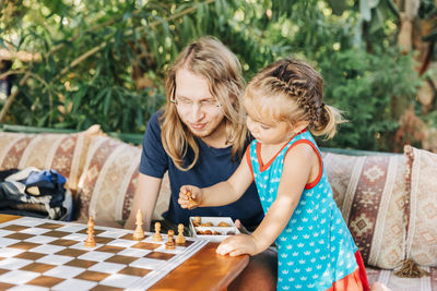 Father playing chess with daughter