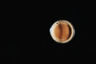 Directly above shot of coffee cup against black background