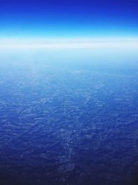 Aerial view of sea against blue sky