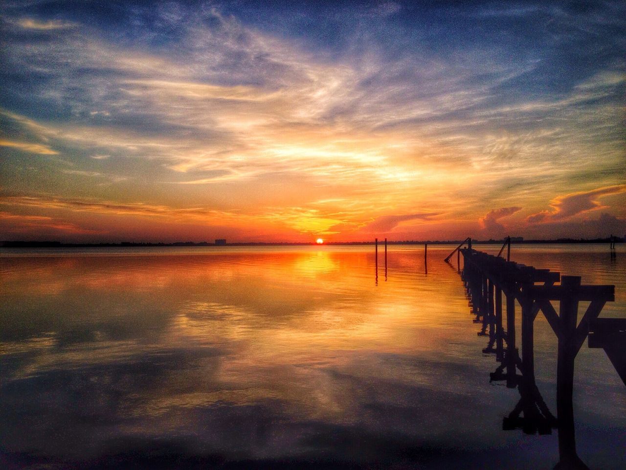 sunset, water, tranquil scene, tranquility, scenics, sky, beauty in nature, pier, orange color, reflection, sea, silhouette, idyllic, cloud - sky, nature, jetty, waterfront, lake, cloud, wooden post