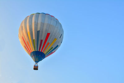 Low angle view of hot air balloon against clear blue sky