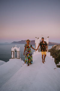 People standing by sea against sky