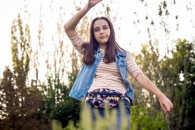 Portrait of young woman standing in forest