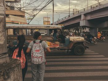 Rear view of people walking on street in city