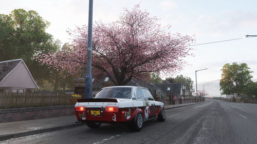 Car on street in city against sky