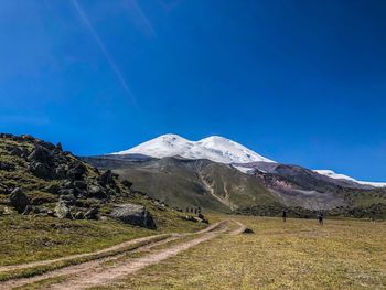 Scenic view of snowcapped mountains against blue sky