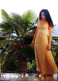 Woman standing by tree against plants