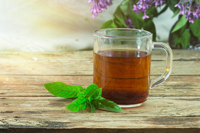 Mint tea in cup on wooden table