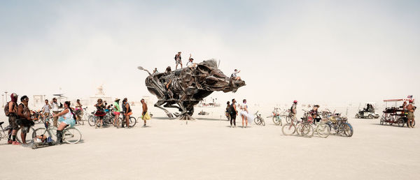 People riding bicycles against clear sky