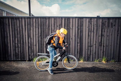 Portrait of smiling boy over bicycle on road