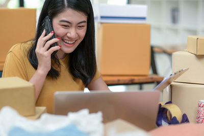 Young woman using mobile phone in box