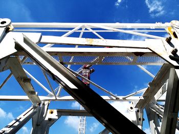 Low angle view of crane at construction site against sky