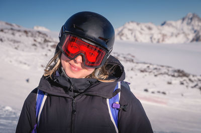 Woman skier on the slope of a mountain resort. portrait of a young woman smiling in ski equipment