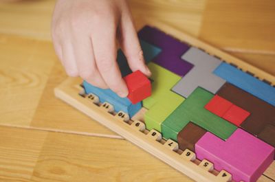 High angle view of hand holding toy on table