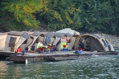 People on lake against trees