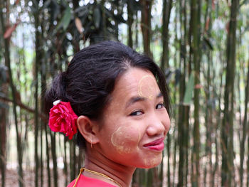 Close-up portrait of a smiling young tribal woman in forest