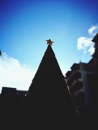 Low angle view of cross against sky