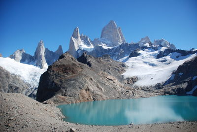 Scenic view of snowcapped mountains against clear blue sky