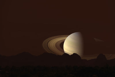 Light trails on silhouette mountain against sky at night