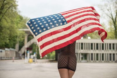 Rear view of woman holding american flag