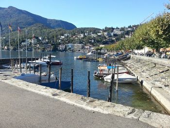 Boats moored at harbor against clear sky
