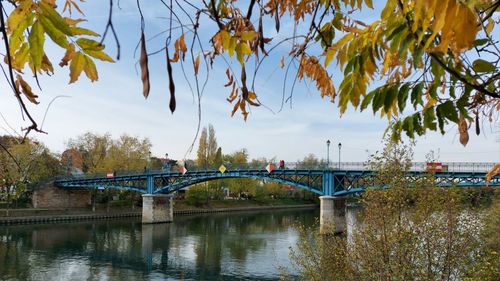 Bridge over river in city against sky