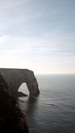 Rock formation in sea against sky