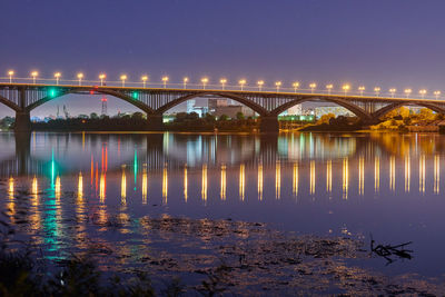 Night city bridge lighting. beautiful reflection of night lights on water surface. long exposure