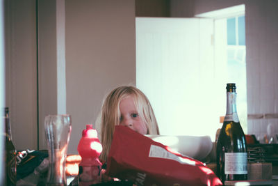 Portrait of girl with wine bottle at home