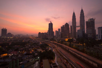 Buildings in city against sky during sunrise