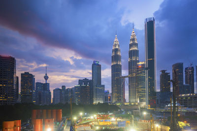 Illuminated buildings in city against sky at night