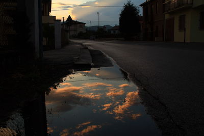 Reflection of sky in puddle on road