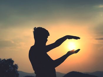 Silhouette woman standing against sky during sunset