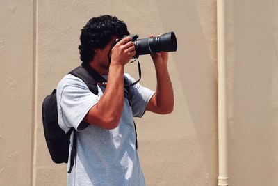 Man photographing against wall