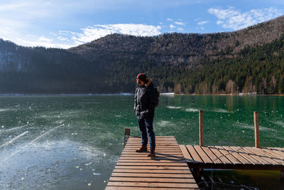 Woman looking at lake against mountain