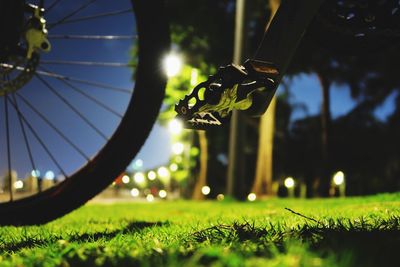 Cropped image of bicycle on grassy field at dusk