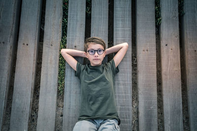 Portrait of boy lying on wooden planks